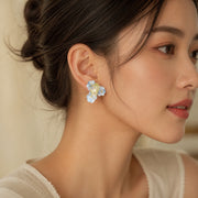Woman wearing one frosted iris Ronghua silk flower stud earring