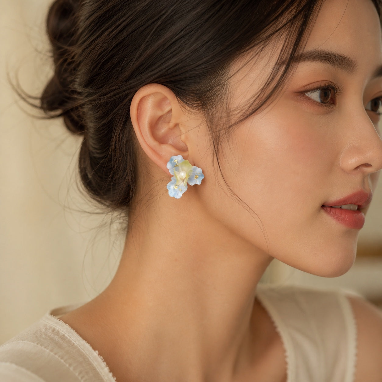 Woman wearing one frosted iris Ronghua silk flower stud earring